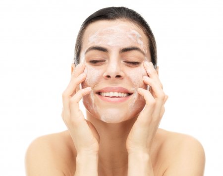 Woman cleansing her face with Gel Moussant Actif 